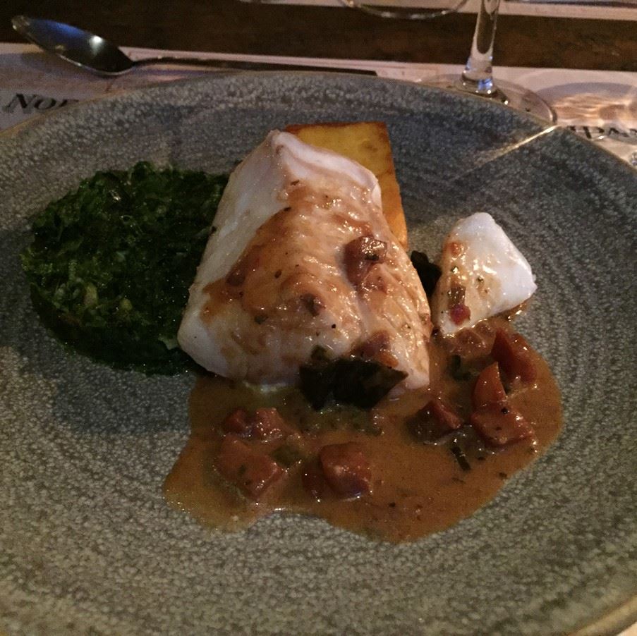 Main course of freshly caught cod, spinach and polenta