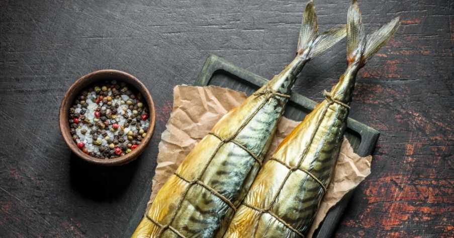 Appetizing Smoked Mackerel on Paper with Spices in Bowl