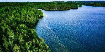 Aerial view of blue lake and green forest in Finland